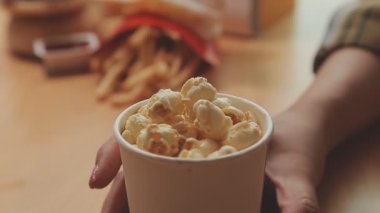 Elinde fast food tutan Asyalı bir kadın aşırı kilolu olma ve sağlıksız beslenmenin etkisini vurguluyor..
