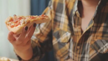 Kadın arka planda pizza yiyor, kapat.