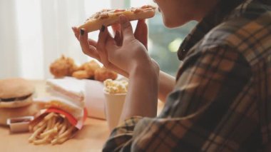 Evde lezzetli abur cubur yiyen bir kadın.