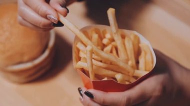 Patates kızartması yiyen kadının yakın plan görüntüsü.