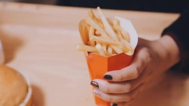 Patates kızartması yiyen kadının yakın plan görüntüsü.