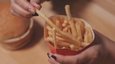 Patates kızartması yiyen kadının yakın plan görüntüsü.