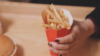 Patates kızartması yiyen kadının yakın plan görüntüsü.