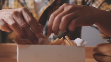 Elinde abur cubur olan Asyalı kadın kötü beslenme alışkanlıklarının ve kilo almanın zorluklarını sembolize ediyor.