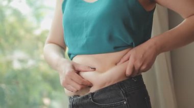 Genç kadın karnına dokunuyor, kilolu konsept geçmişi