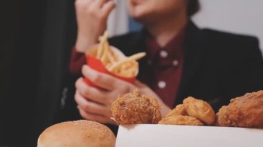 Fast food yiyen birinin yakın plan fotoğrafı.