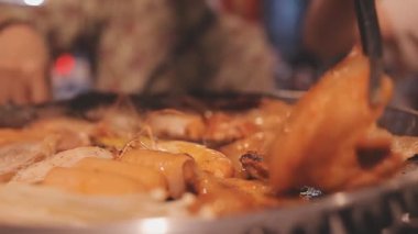 İnsanlar ızgarada et ve deniz ürünleri pişiriyor, Yakiniku Japonya 'nın en popüler yemek pişirme tarzlarından biridir..