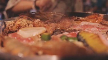 İnsanlar ızgarada et ve deniz ürünleri pişiriyor, Yakiniku Japonya 'nın en popüler yemek pişirme tarzlarından biridir..
