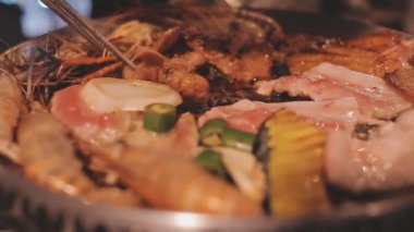 İnsanlar ızgarada et ve deniz ürünleri pişiriyor, Yakiniku Japonya 'nın en popüler yemek pişirme tarzlarından biridir..