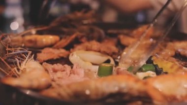 İnsanlar ızgarada et ve deniz ürünleri pişiriyor, Yakiniku Japonya 'nın en popüler yemek pişirme tarzlarından biridir..