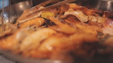 İnsanlar restoranda geleneksel Yakiniku usulü ızgara et ve karides pişiriyor..