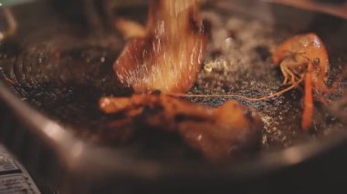 İnsanlar ızgarada et ve deniz ürünleri pişiriyor, Yakiniku Japonya 'nın en popüler yemek pişirme tarzlarından biridir..