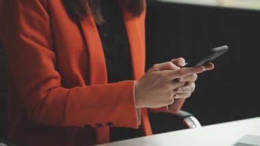 İş kadını iş yerinde akıllı telefon kullanıyor.