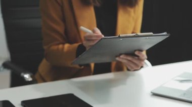 Modern ofiste dizüstü bilgisayarla çalışan genç bir kadın..