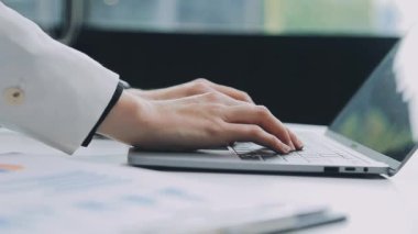 Genç işadamı ofiste dizüstü bilgisayarla çalışıyor..