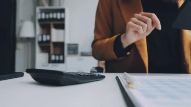 Ofisteki masada hesap makinesi kullanan kadın