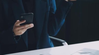 İş adamı masasında akıllı telefon kullanıyor.