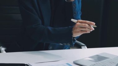 Ofiste dijital tablet kullanan bir iş kadını. Genç iş kadını kağıda yazıyor.