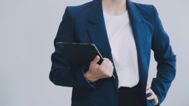 Ofisteki beyaz arkaplanda dijital tablet kullanan genç kadın