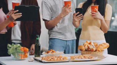 Arkadaşları kafede kahve içerken Asyalı genç adam tablet kullanıyor..