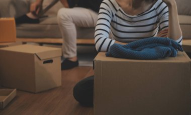 İki Asyalı blogcu, dükkanında canlı yayın yapan videoyu kaydetmek için kameranın önünde kıyafetlerini gösteriyor. Çevrimiçi alışveriş arabası fikri. Evdeki kanepede.