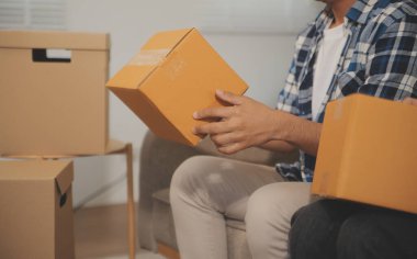 İki Asyalı blogcu, dükkanında canlı yayın yapan videoyu kaydetmek için kameranın önünde kıyafetlerini gösteriyor. Çevrimiçi alışveriş arabası fikri. Evdeki kanepede.