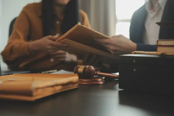 Adalet ve hukuk kavramı. Hukuk Müşaviri tokmak ve yasal hukuk veya yasal ile imzalanmış bir sözleşme istemciye sunar arka planda hukuk firmasında takım toplantısı