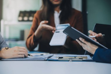 İş ekibi ile yeni başlangıç planı ve tartışma için proje bilgilerini dizüstü bilgisayar ve dijital tablet ile mali strateji bir modern iş salonda çalışıyor.