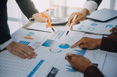 İş ekibi ile yeni başlangıç planı ve tartışma için proje bilgilerini dizüstü bilgisayar ve dijital tablet ile mali strateji bir modern iş salonda çalışıyor.