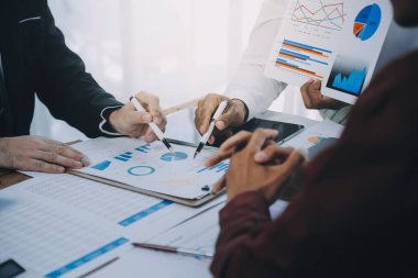 İş ekibi ile yeni başlangıç planı ve tartışma için proje bilgilerini dizüstü bilgisayar ve dijital tablet ile mali strateji bir modern iş salonda çalışıyor.