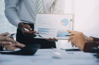 İş ekibi ile yeni başlangıç planı ve tartışma için proje bilgilerini dizüstü bilgisayar ve dijital tablet ile mali strateji bir modern iş salonda çalışıyor.