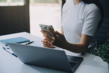 Heyecanlı mutlu Asyalı kadın telefon ekranına bakıyor, online bir galibiyeti kutluyor, aşırı neşeli genç Asyalı kadın sevinçten çığlık atıyor, beyaz bulanık bir arka planda izole edilmiş.