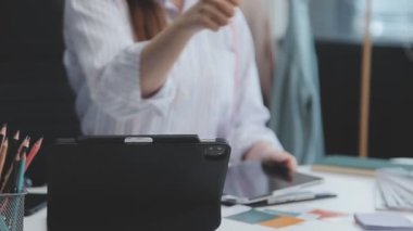 Genç bir iş kadını, iş ve finans kavramlarını ön plana çıkaran bir fon ile çağdaş bir ofiste çalışırken resmedilir..