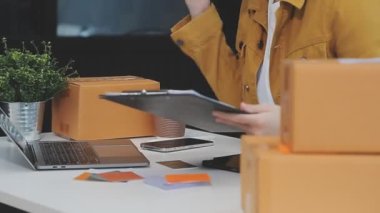Kadın girişimci bir dizüstü bilgisayar ve paketleme kutusu üzerinde çalışıyor, iş dünyası online dağıtım konsepti. çevrimiçi iş ve online dağıtım kavramı.