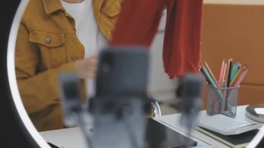 Genç Asyalı kadın video yayını, moda blogcusu ve çevrimiçi iş konseptiyle ürünler satıyor 