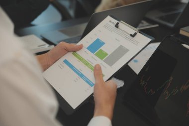 İş ekibi işbirliği mali veriler ve pazarlama büyüme raporlarıyla analiz etmeyi takım halinde, şirket kârından yararlanmak için strateji planlama, sunum ve beyin fırtınası grafiği üzerinde tartışır..