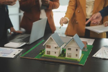 Mimarlar ve iş adamları, emlak yatırımları ve konut geliştirme projesi için zemin planı modifikasyonunu tartışıp fikir alışverişinde bulunuyorlar.