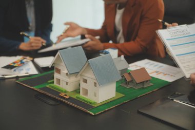 Mimarlar ve iş adamları, emlak yatırımları ve konut geliştirme projesi için zemin planı modifikasyonunu tartışıp fikir alışverişinde bulunuyorlar.