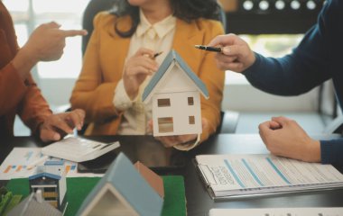 Mimarlar ve iş adamları, emlak yatırımları ve konut geliştirme projesi için zemin planı modifikasyonunu tartışıp fikir alışverişinde bulunuyorlar.