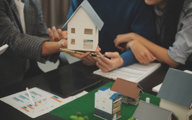 Mimarlar ve iş adamları, emlak yatırımları ve konut geliştirme projesi için zemin planı modifikasyonunu tartışıp fikir alışverişinde bulunuyorlar.