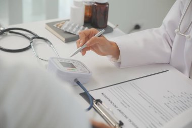Erkek doktor, check-up, tıbbi tedavi ve sağlık konsepti için hastaneye gelen hastaların vücut basıncını ve nabzını ölçmek için kan basıncı monitörü kullanır..