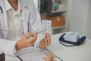 Healthcare service and pharmacy worker with customer at store counter for medication explanation. Pharmaceutical advice and opinion of pharmacist helping girl with medicine information.