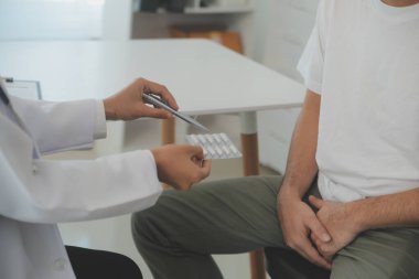 Erkek hastalıkları. Adam ellerini kasıklarına bastırıyor ve acı çekiyor. Panorama, kesilmiş, stüdyo çekimi.