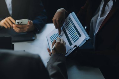 İş ekibi ile yeni başlangıç planı ve tartışma için proje bilgilerini dizüstü bilgisayar ve dijital tablet ile mali strateji bir modern iş salonda çalışıyor.
