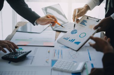 İş ekibi ile yeni başlangıç planı ve tartışma için proje bilgilerini dizüstü bilgisayar ve dijital tablet ile mali strateji bir modern iş salonda çalışıyor.