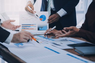 İş ekibi ile yeni başlangıç planı ve tartışma için proje bilgilerini dizüstü bilgisayar ve dijital tablet ile mali strateji bir modern iş salonda çalışıyor.