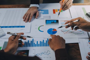 İş ekibi ile yeni başlangıç planı ve tartışma için proje bilgilerini dizüstü bilgisayar ve dijital tablet ile mali strateji bir modern iş salonda çalışıyor.