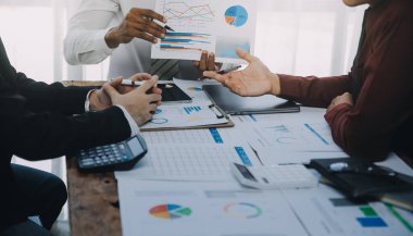 İş ekibi ile yeni başlangıç planı ve tartışma için proje bilgilerini dizüstü bilgisayar ve dijital tablet ile mali strateji bir modern iş salonda çalışıyor.