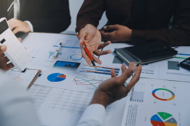 İş ekibi işbirliği mali veriler ve pazarlama büyüme raporlarıyla analiz etmeyi takım halinde, şirket kârından yararlanmak için strateji planlama, sunum ve beyin fırtınası grafiği üzerinde tartışır..