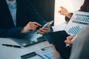 İş ekibi ile yeni başlangıç planı ve tartışma için proje bilgilerini dizüstü bilgisayar ve dijital tablet ile mali strateji bir modern iş salonda çalışıyor.